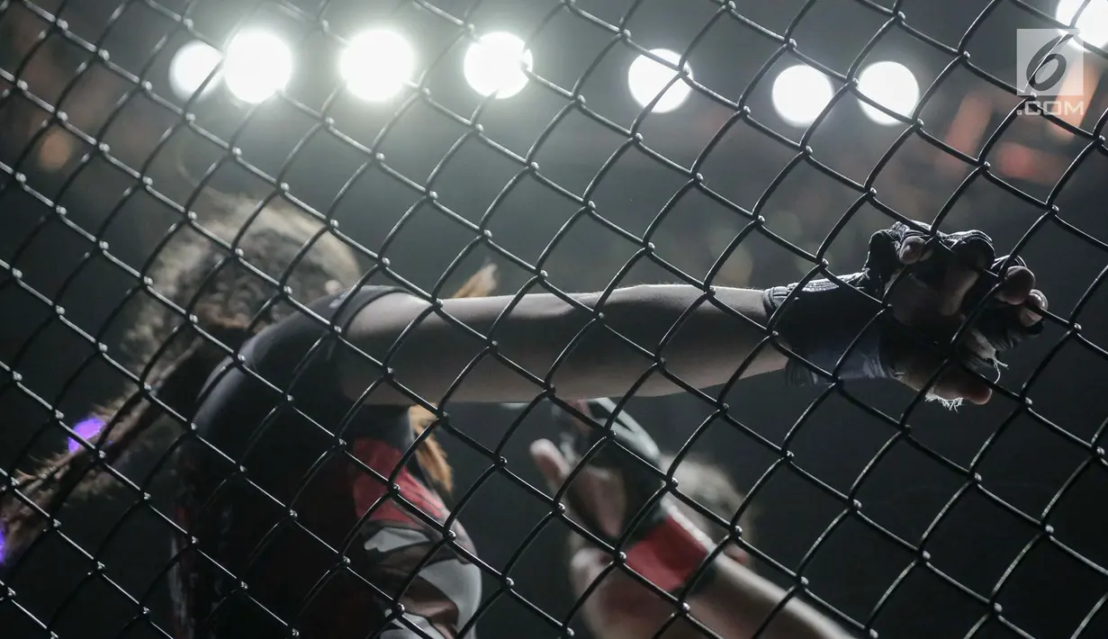 Petarung putri Malaysia, Audreylaura Boniface (kiri) menahan tendangan dari petarung Indonesia, Priscilla Hertati Lumban Gaol (kanan) saat berlaga pada partai pertama One Championship di Jakarta, Sabtu (20/1). (Liputan6.com/Faizal Fanani)