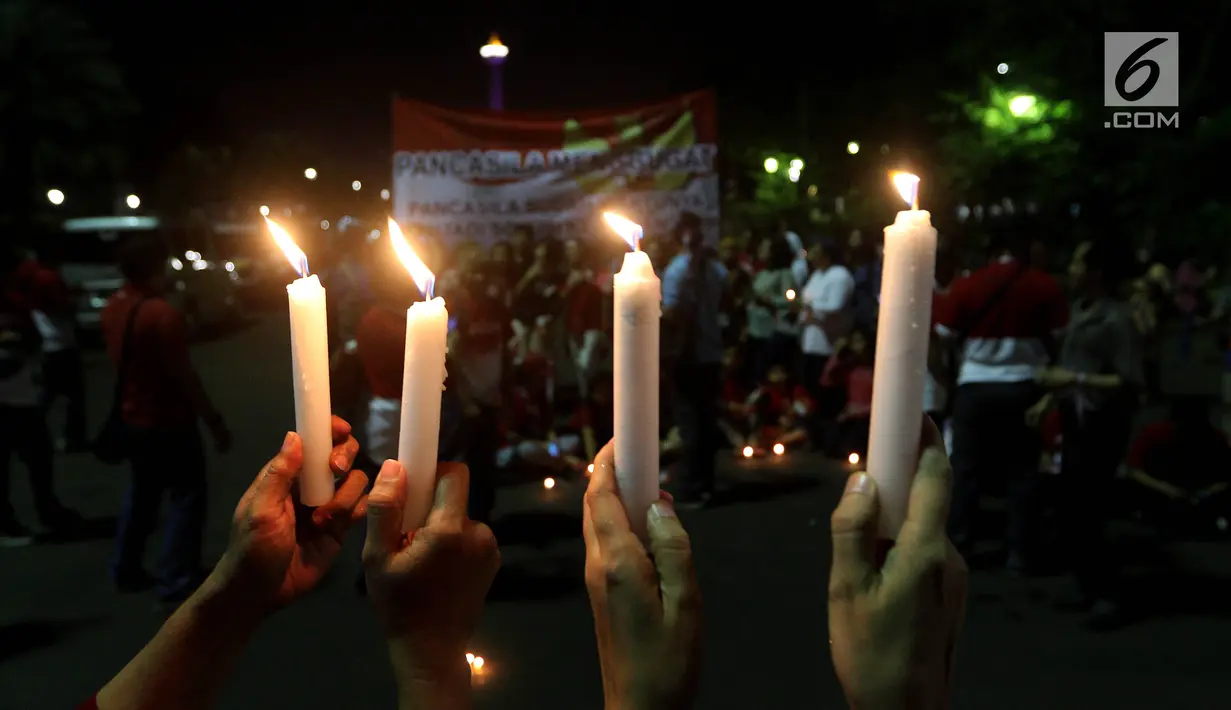 Masyarakat yang tergabung dalam Silent Majority Forum melakukan aksi damai dengan menyalakan lilin di Silang Monas, Jakarta, Kamis (1/6). Mereka mengutuk dengan keras segala bentuk intoleransi, radikalisme, terorisme, dan intimidasi.(Liputan6/JohanTallo)