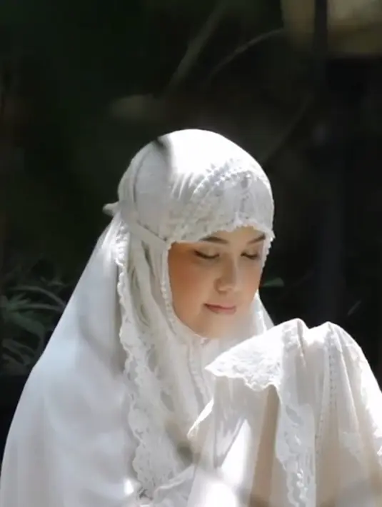 Gaya hijab yang dikenakan Annisa Pohan dalam foto ini adalah model mukena berwarna putih polos dengan desain sederhana namun elegan. Mukena ini memiliki potongan yang longgar dan nyaman, dengan aksen renda di bagian bawah yang menambah kesan anggun. (Liputan6.com/IG/@annisayudhoyono)