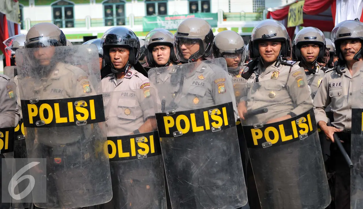 Personel Polres Tangerang Selatan memperagakan tindak penanganan kerusuhan yang dilakukan pengunjukrasa dalam simulasi pengamanan pilkada Tangerang Selatan di Polres Jakarta Selatan, Rabu (9/9/2015). (Liputan6.com/Gempur M Surya)