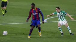 Penyerang Barcelona, Ousmane Dembele berusaha mengontrol bola dari kawalan pemain Real Betis, Andres Guardado pada lanjutan La Liga Spanyol di stadion Benito Villamarin di Seville, Spanyol, Senin (8/2/2021).  Kini Barcelona mengumpulkan 43 poin dari 21 laga. (AP Photo/Miguel Morenatti)