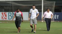 Pelatih Bhayangkara FC, Simon McMenemy (tengah) memantau lapangan saat hujan sebelum memulai sesi latihan di Stadion Patriot Bekasi, Sabtu (11/11/2017). Latihan tersebut jelang melawan Persija. (Bola.com/Nicklas Hanoatubun)