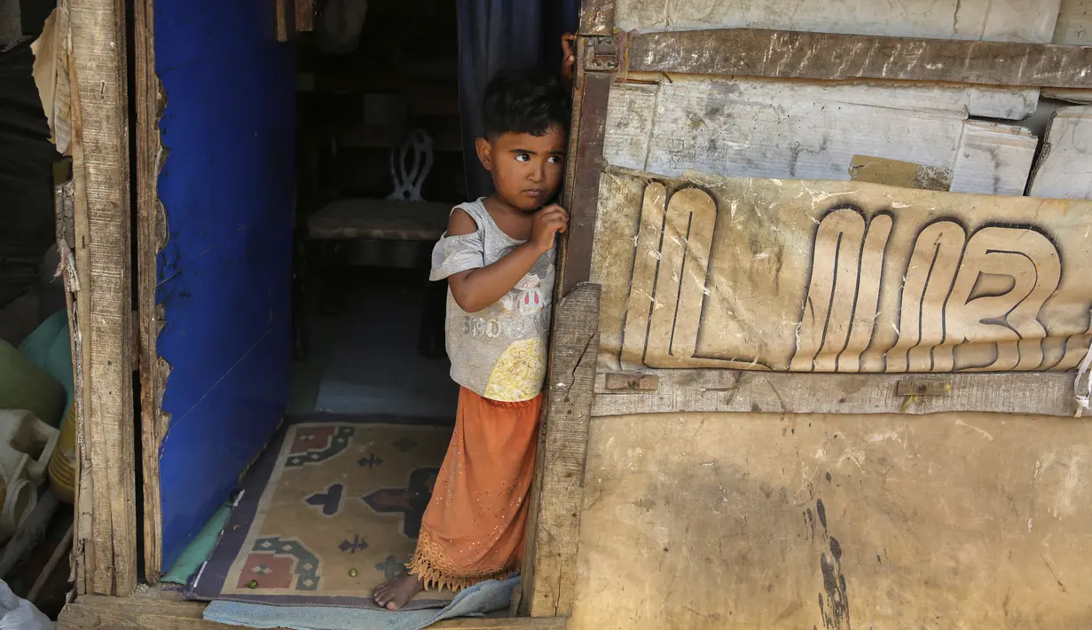 Gadis pengungsi Rohingya berdiri di kamp darurat di pinggiran Jammu, India, 7 Maret 2021. Pihak berwenang di Kashmir yang dikuasai India telah mengirim setidaknya 168 pengungsi Rohingya ke pusat penampungan untuk mendeportasi ribuan pengungsi yang tinggal di wilayah tersebut. (AP Photo/Channi Anand)