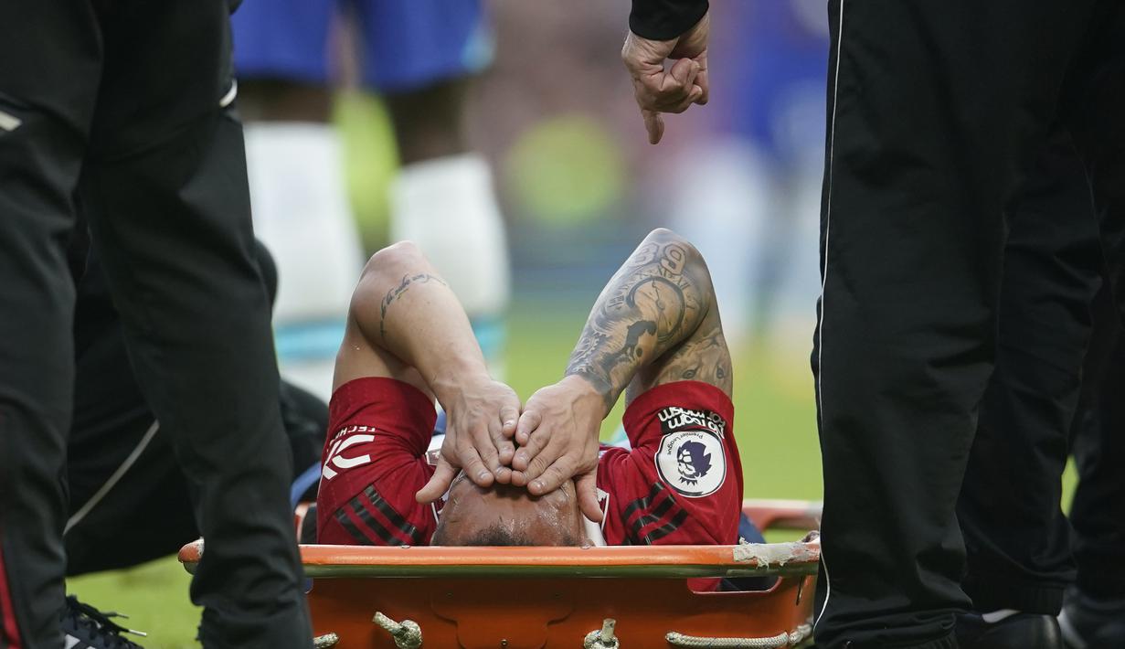 Pemain Manchester United, Antony (tengah), tidak dapat melanjutkan pertandingan dan harus ditandu keluar lapangan setelah dilanggar Pemain Chelsea dalam pertandingan partai tunda pekan ke-32 Liga Inggris 2022/2023 yang berlangsung di Old Trafford, Jumat (26/5/2023) dini hari WIB. (AP Photo/Dave Thompson)