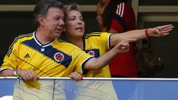 Bersama sang istri, Maria Clemencia (kanan), Presiden Kolombia Juan Manuel Santos, berada di tribun kehormatan Stadion National Mane Garrincha, Brasil, (19/6/2014), menyaksikan langsung James Rodriguez dkk melawan Pantai Gading. (REUTERS/Paul Hanna)