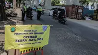 Polisi lalu lintas menggelar Operasi Zebra 2019 di Jalan Boulevard Gading Raya, Jakarta, Kamis (24/10/2019). Operasi selama dua pekan hingga 5 November mendatang tersebut untuk meningkatkan kepatuhan dan kedisiplinan pengendara kendaraan bermotor dalam berlalu lintas. (Liputan6.com/Faizal Fanani)