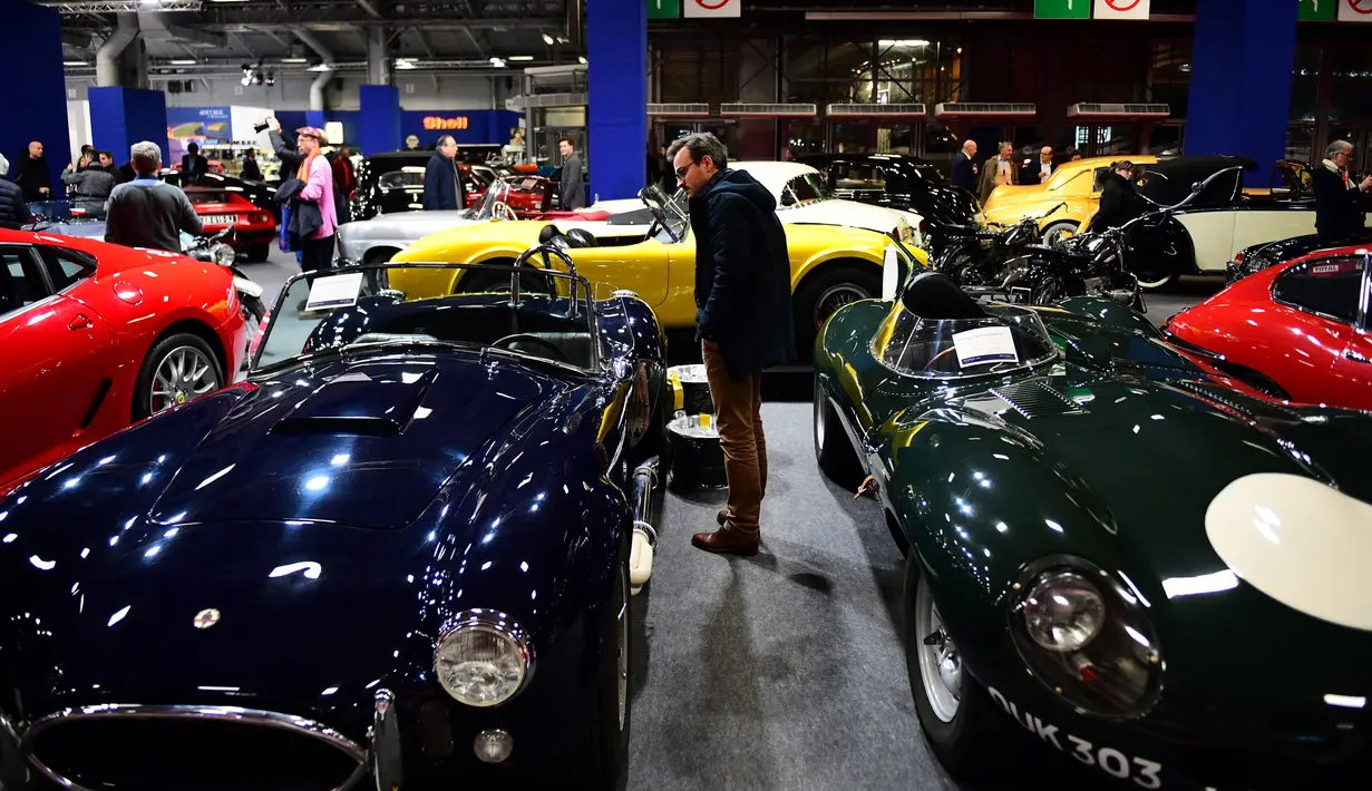 Seorang lelaki memandangi sebuah mobil tua yang ditampilkan selama pameran mobil klasik Retromobile di Porte de Versailles, di Paris (4/2/2020). Retromobile berlangsung dari 5 Februari hingga 9 Februari 2020. (AFP Photo/Martin Bureau)