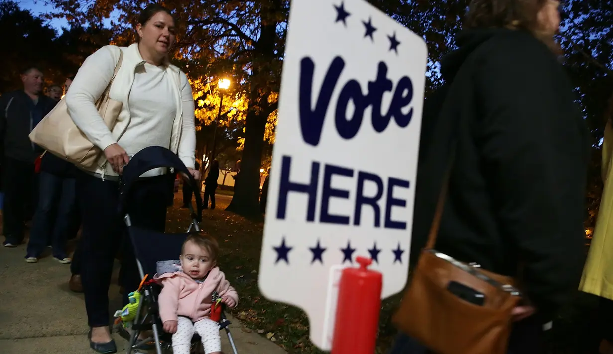 Warga mengajak bayinya saat akan memberikan suara pemilihan presiden AS di Alexandria, Virginia, AS, Selasa (8/11). Warga AS akan menentukan presiden mereka antara Hillary Clinton dan Donald Trump. (AFP Photo/Alex Wong)