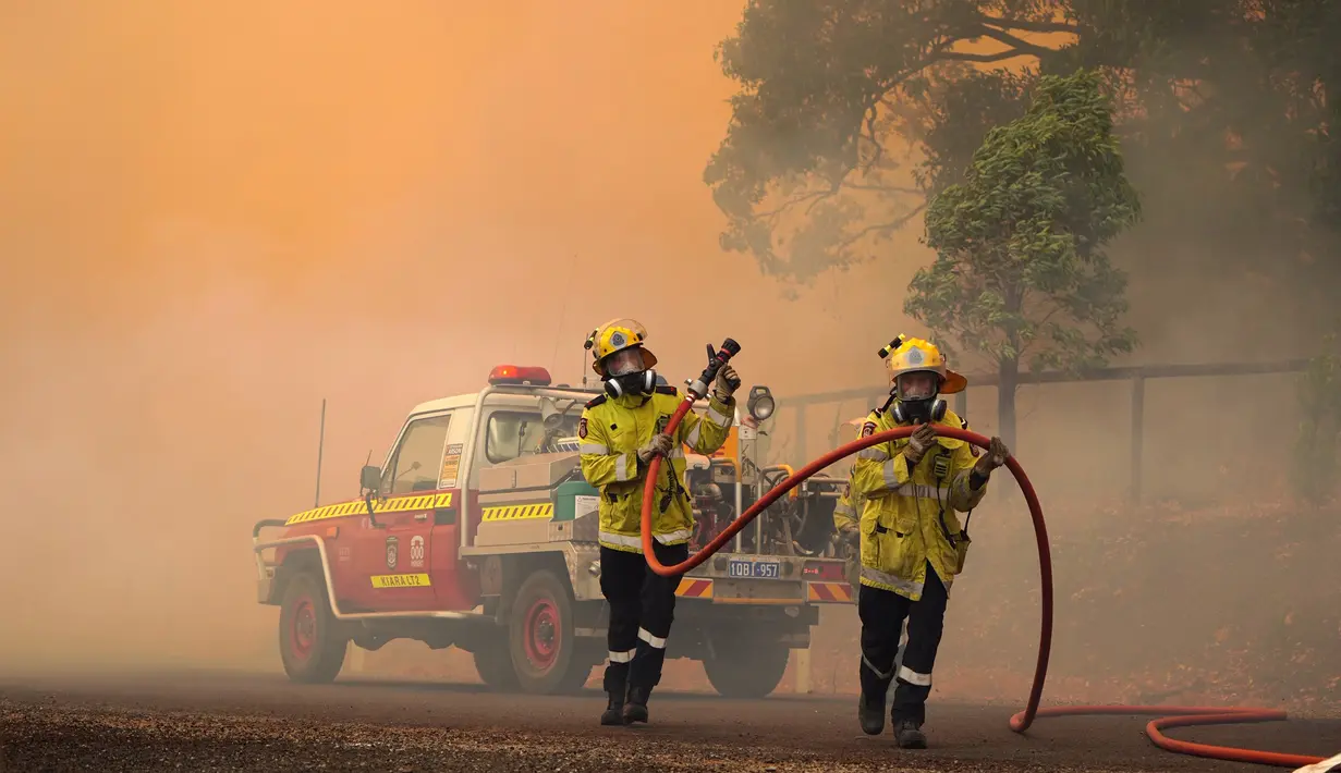 Petugas pemadam kebakaran berusaha menjinakkan kobaran api di dekat Wooroloo, timur laut Perth, Australia, Selasa (2/1/2021). Asap dan api dari kebakaran hutan membakar kota terbesar keempat di Australia ini, di tengah pemberlakuan lockdown virus corona COVID-19. (Evan Collis/DFES via AP)