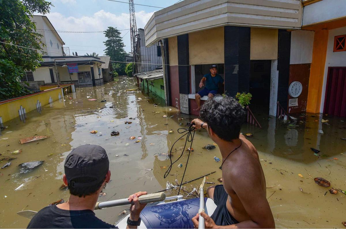 FOTO: Banjir Luapan Kali Angke, Pemuda Tangerang Bahu-Membahu Evakuasi Warga
