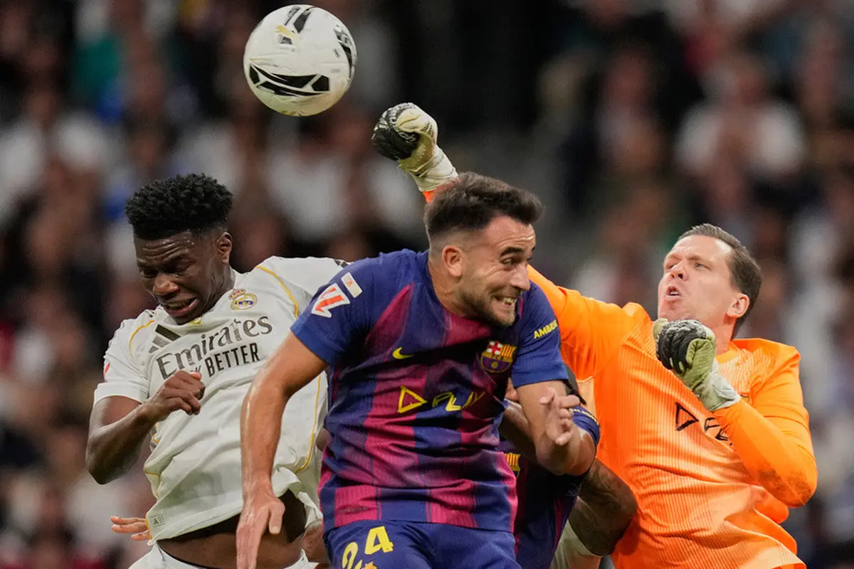 Kiper Barcelona, Wojciech Szczesny, meninju bola melewati Aurelien Tchouameni dari Real Madrid