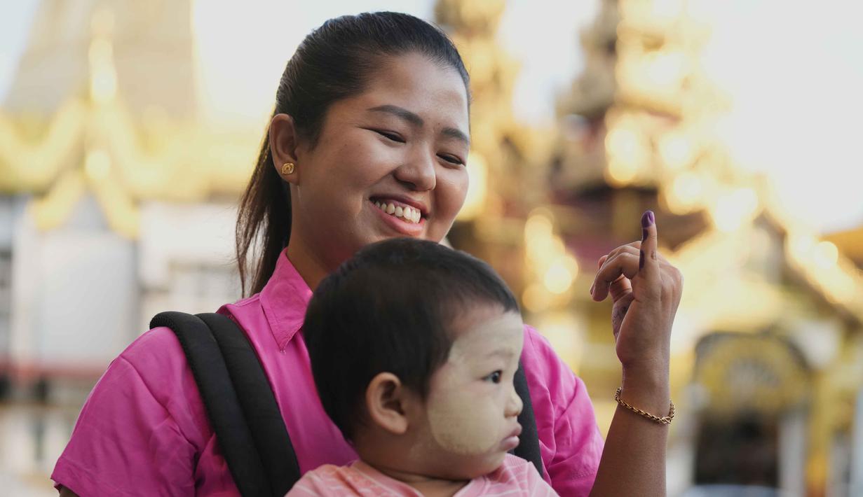 Sementara, tahap ketiga digelar 25 Januari 2026. Tampak dalam foto, seorang pemilih memperlihatkan jarinya yang ditandai dengan tinta sebagai tanda telah memilih, saat meninggalkan tempat pemungutan suara, berlatar belakang Pagoda Sule, di Yangon, Myanmar, Minggu, 28 Desember 2025,  (AP Photo/Thein Zaw)