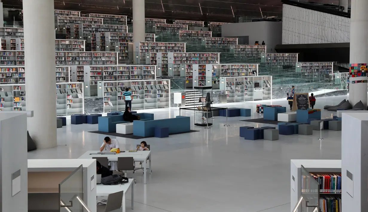 Orang-orang menggunakan area baca Perpustakaan Nasional Qatar di ibu kota Doha pada 19 Mei 2019. Bangunan megah karya arsitek Rem Koolhaas ini memiliki luas 45 ribu meter persegi. (KARIM JAAFAR / AFP)