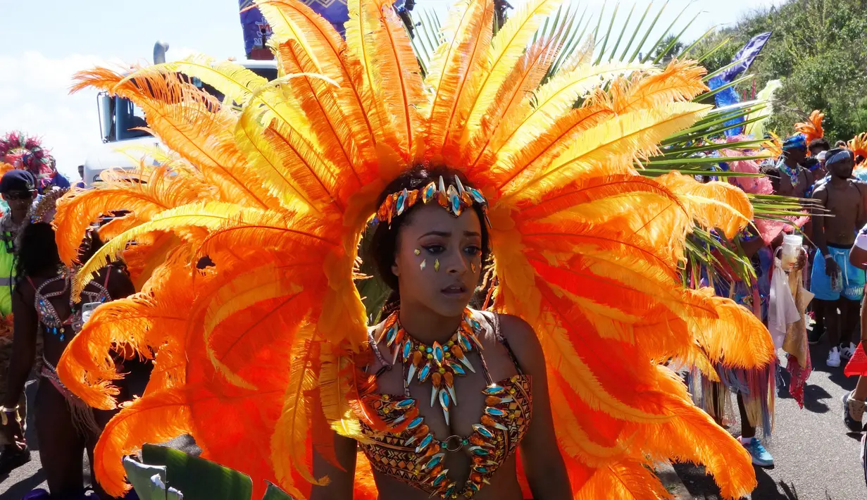 Seorang penari mengenakan kostum lengkap dengan aksesorisnya bersiap mengikuti perayaan Hari Pahlawan Nasional di St. David's, Bermuda (19/6). Kawasan bermuda ini juga terkenal akan keindahan alam dan pantainya.(AFP Photo/Don Emmert)