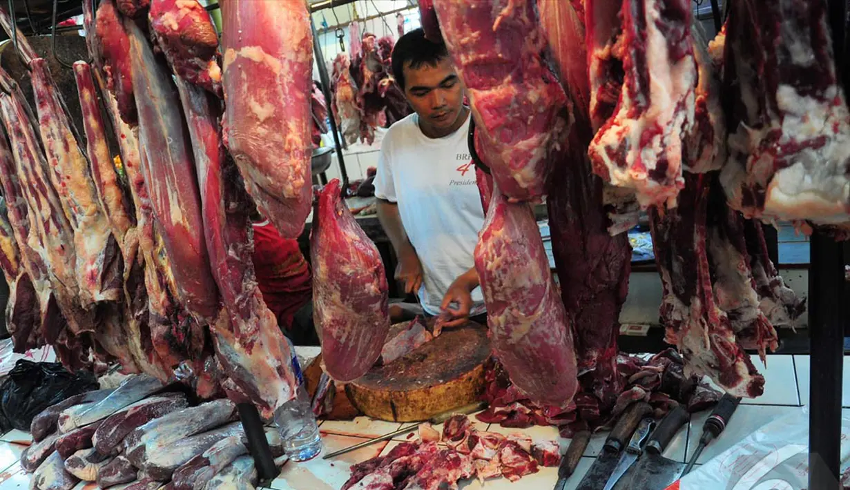Seorang pedagang memotong daging sapi menjadi bagian yang lebih kecil, Pasar Senen, Jakarta, Rabu (25/6/2014) (Liputan6.com/Faizal Fanani)