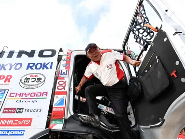 Pembalap Hino Yoshimasa Sugawara dari Jepang keluar dari truknya saat melakukan pemeriksaan teknis jelang Reli Dakar 2018 di Lima, Peru (3/1). Hino satu-satunya brand truk asal Jepang yang ambil bagian dalam edisi ke-40 Reli Dakar. (AFP Photo/Franck Fife)