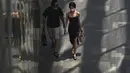 Sepasang kekasih yang mengenakan masker berjalan melalui pusat perbelanjaan di Beijing, Senin (6/6/2022). Pengunjung kembali ke restoran di sebagian besar Beijing untuk pertama kalinya dalam lebih dari sebulan sebagai pihak berwenang lebih lanjut melonggarkan pembatasan terkait pandemi wabah COVID-19. (AP Photo/Andy Wong)