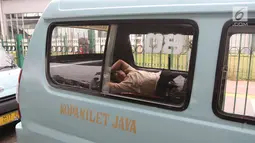 Seorang sopir angkot M08 trayek Tanah Abang-Kota tertidur di dalam kendaraannya di Jalan Jatibaru, Jakarta, Kamis (22/2). Para sopir terlihat sedang menunggu rekan sopir M03 dan M10 yang juga akan ikut berunjuk rasa. (Liputan6.com/Arya Manggala)