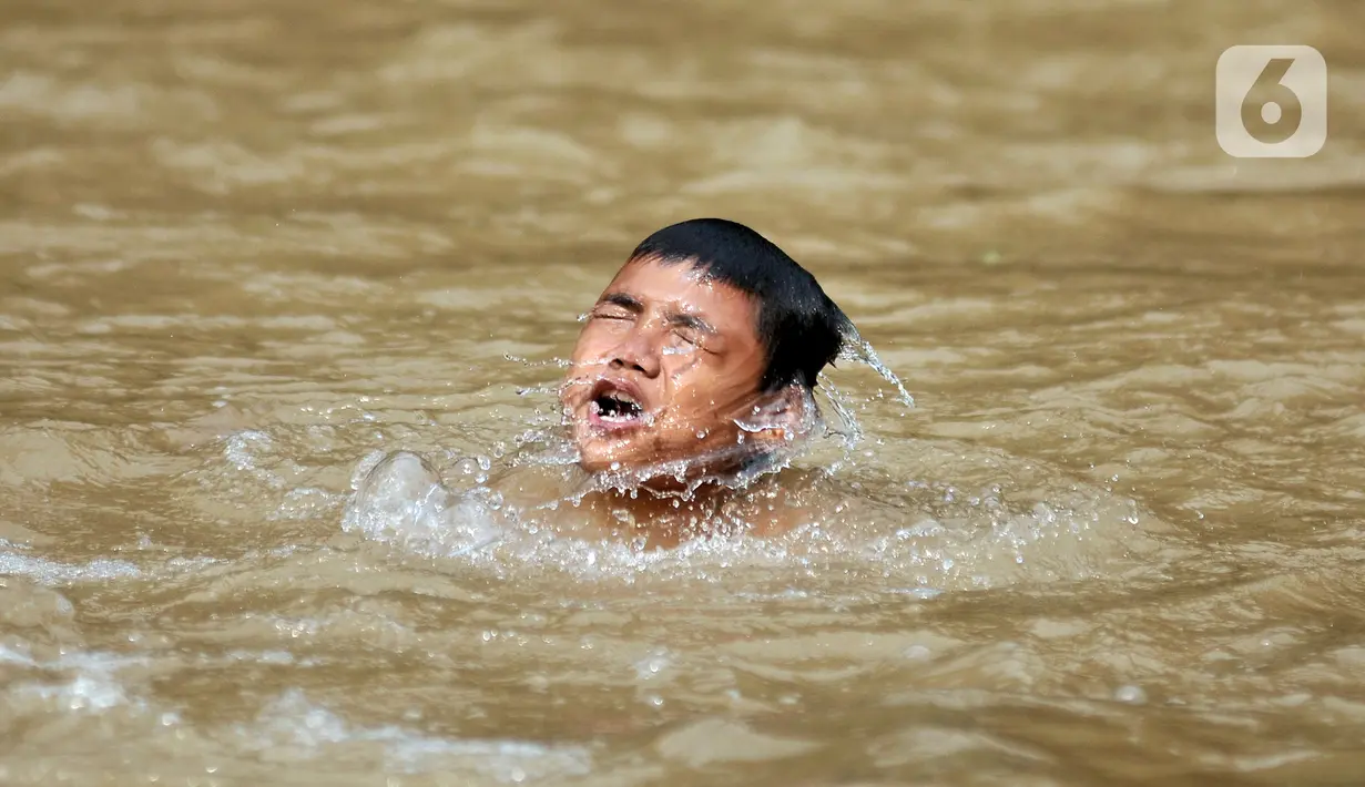 Seorang anak berenang di Kali Ciliwung, Depok, Jawa Barat, Minggu (27/6/2021). Keterbatasan lahan bermain di tengah masa pandemi COVID-19 membuat anak-anak memilih untuk berenang di Kali Ciliwung sebagai wahana alternatif saat libur sekolah. (merdeka.com/Iqbal S. Nugroho)