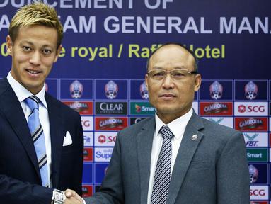 Gelandang Jepang Keisuke Honda (kiri) berpose dengan presiden federasi sepak bola Kamboja Sao Sokha selama konferensi pers di Phnom Penh (12/8). Eks gelandang AC Milan ini resmi menjadi pelatih kepala Timnas Kamboja. (AFP Photo)