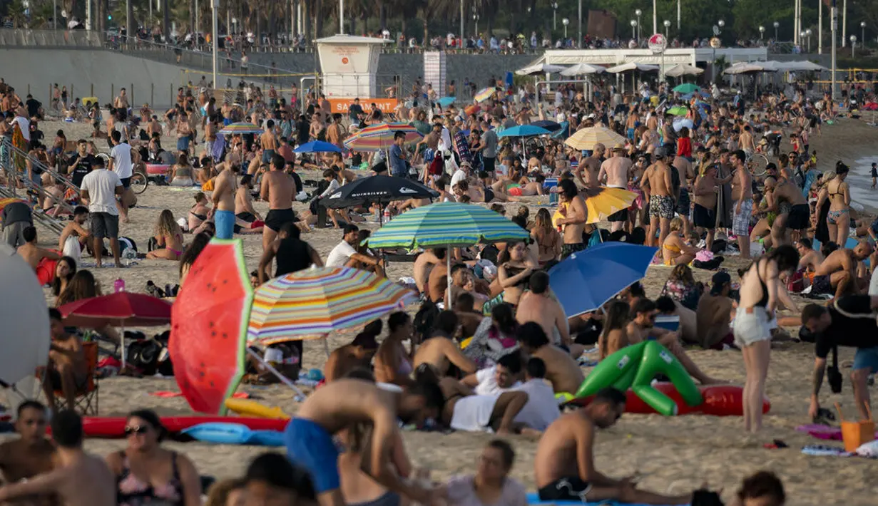 Orang-Orang menikmati cuaca panas di pantai di Barcelona, Spanyol, Kamis (12/8/2021). Bagian timur laut Spanyol, di wilayah Catalonia, diperkirakan mencapai 42 derajat Celcius pada hari Kamis. (AP Photo/Joan Mateu Parra)