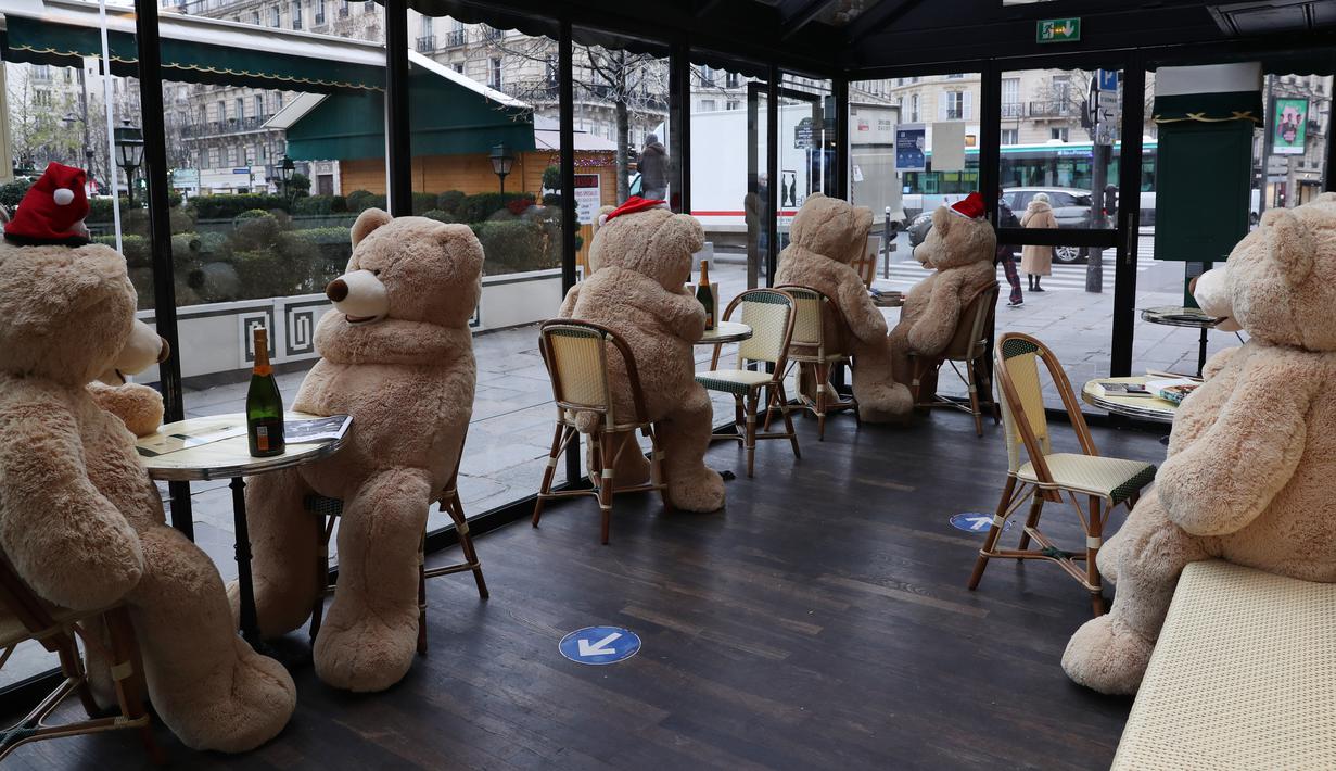 Sejumlah boneka beruang raksasa terlihat di kafe Les Deux Magots yang ditutup di Paris, Prancis pada 16 Desember 2020. Otoritas kesehatan Prancis pada Rabu (16/12) melaporkan 17.615 kasus infeksi COVID-19 tambahan dalam 24 jam terakhir, penambahan harian terbesar sejak 21 November. (Xinhua/Gao Jing)