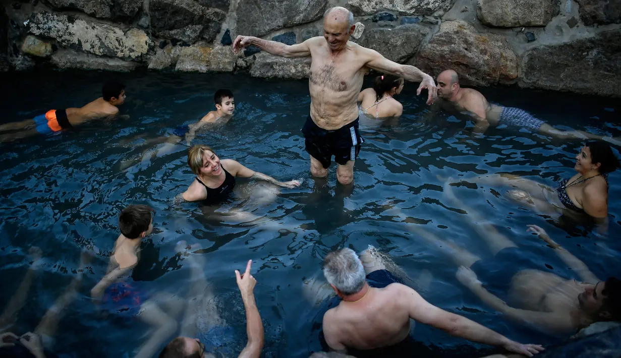 Jose Antonio Aznarez (tengah) bersama yang lain menikmati pemandian air panas alami Sungai Cidaco dengan suhu 52 Celcius saat pagi musim dingin di desa kecil Arnedillo, Spanyol utara, 29 Desember 2018. (AP Photo/Alvaro Barrientos)