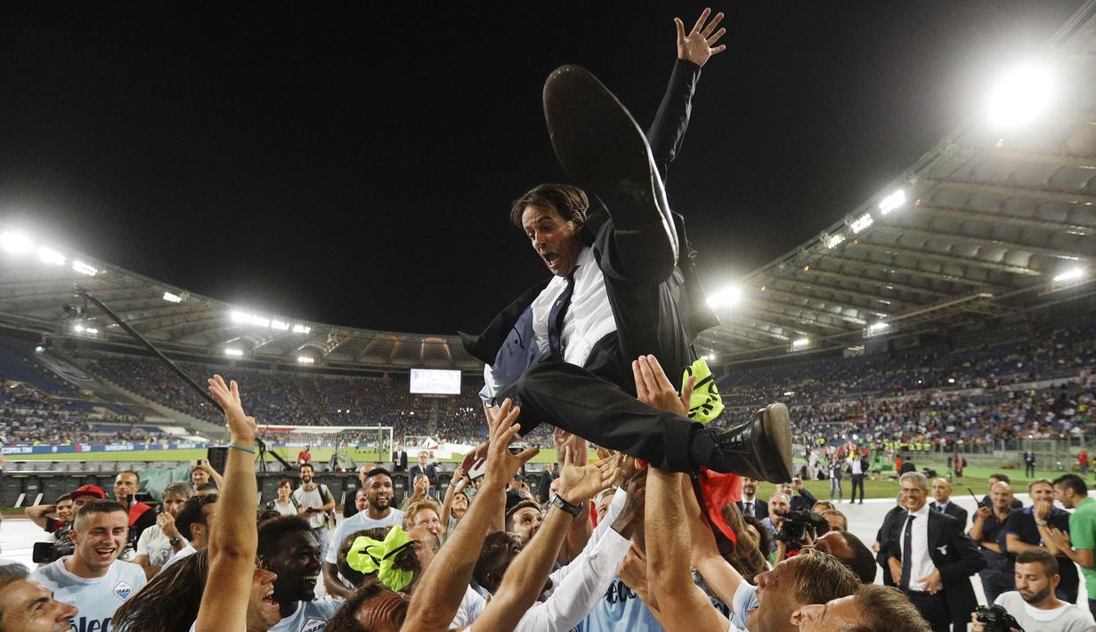 Pelatih Lazio, Simone Inzaghi, diangkat para pemain usai berhasil menjuarai Supercoppa Italiana 2017 dengan mengalahkan Juventus di Stadion Olimpico, Minggu, (13/8/2017). Lazio menang 3-2 atas Juventus. (AP/Gregorio Borgia)