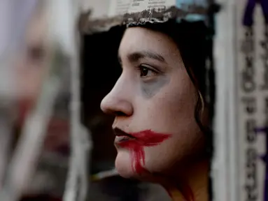 Seorang wanita ikut dalam demonstrasi menentang kekerasan gender di Buenos Aires, Argentina, Sabtu (3/6). Demonstran membawa hashtag #NiUnaMenos, yang berarti "tidak sedikit". (Foto AP / Natacha Pisarenko)