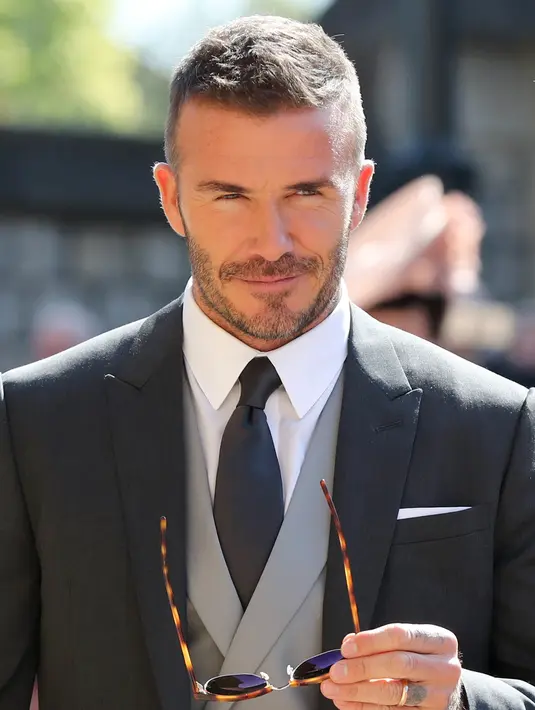 Gaya mantan pemain sepak bola Inggris, David Beckham saat menghadiri pernikahan Pangeran Harry dan Meghan Markle di St. George's Chapel, Kastil Windsor, Inggris, Sabtu (19/5). (GARETH FULLER/POOL/AFP)