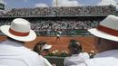 Garbine Muguruza berjalan sambil membersihkan wajahnya dari keringat saat melawan Anett Kontaveit pada ajang Prancis Terbuka di Roland Garros stadium, Paris, (31/5/2017). (AP/Petr David Josek)