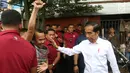 Presiden Joko Widodo atau Jokowi melihat ke arah warga yang antusias menyambut kedatangannya di Pasar Minggu, Jakarta, Jumat (22/2). Jokowi harus meladeni permintaan salam dan foto dari pedagang dan warga. (Liputan6.com/Angga Yuniar)