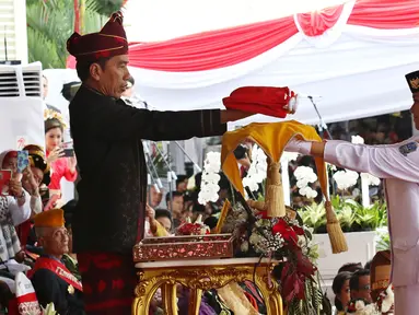 Presiden Jokowi menyerahkan Bendera Merah Putih kepada Fariza Putri Salsabila, anggota Pasukan Pengibar Bendera Pusaka (Paskibraka), saat Upacara Peringatan Detik-detik Proklamasi 17 Agustus di Istana, Jakarta, Kamis (17/8). (Liputan6.com/Pool)