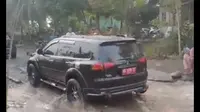 Momen mobil dinas berpelat merah melintasi jalan rusak yang digenangi air di Jalan Lintas Bengkulu Lebong membuat miris orang yang melihat. (Liputan6.com/ Dok Ist)