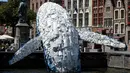 Sebuah instalasi patung paus terbuat dari 5 ton sampah plastik yang ditampilkan di sungai Brugges, Belgia, Sabtu (14/7). Patung paus tersebut bertujuan untuk menyoroti ancaman yang diakibatkan oleh penggunaan plastik secara besar-besaran. (AFP/JOHN THYS)