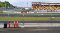 Tiga orang marshal bekerja di salah satu pos Sirkuit Mandalika pada gelaran MotoGP Mandalika 2022, Minggu (20/3/2022). (Hendry Wibowo/Bola.com)