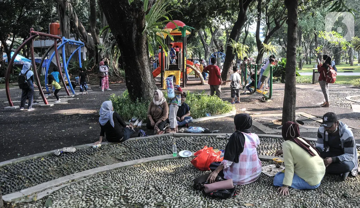 Warga bersantai saat berkunjung ke Lapangan Banteng, Jakarta Pusat, Minggu (19/6/2022). Sejak kembali dibuka usai pandemi COVID-19 mereda, Lapangan Banteng kian ramai didatangi warga Jakarta dan menjadi salah satu lokasi wisata alternatif untuk menghabiskan waktu bersama keluarga serta sarana olahraga. (merdeka.com/Iqbal S. Nugroho)