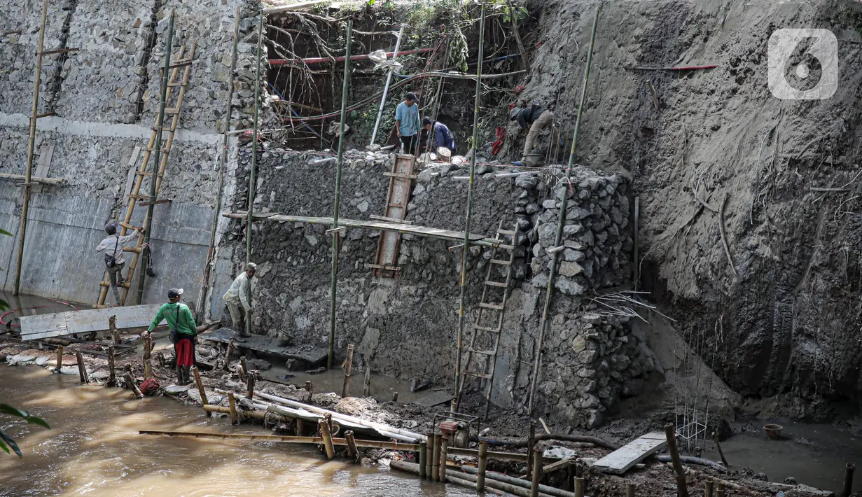 Pekerja menyelesaikan pengerjaan turap di bantaran Kali Kramat Jati, Jakarta, Jumat (20/1/2023). Pembangunan turap bertujuan untuk mencegah longsor yang dapat membahayakan warga sekitar. (Liputan6.com/Faizal Fanani)