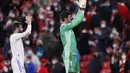 Kiper Real Madrid, Thibaut Courtois (kanan) menyapa pendukungnya usai pertandingan melawan Athletic Bilbao pada pertandingan La Liga Spanyol di stadion San Mames, Spanyol, Kamis (23/12/2021). Madrid menang atas Bilbao 2-1. (AP Photo/Ricardo Larreina)