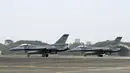 Dua pesawat tempur F-16V bersenjata bersiap pada landasan sebelum lepas landas di pangkalan angkatan udara, Chiayi, Taiwan, 5 Januari 2022. Militer Taiwan menggelar latihan tempur darat, laut, dan udara di tengah ketegangan dengan China. (Sam Yeh/AFP)