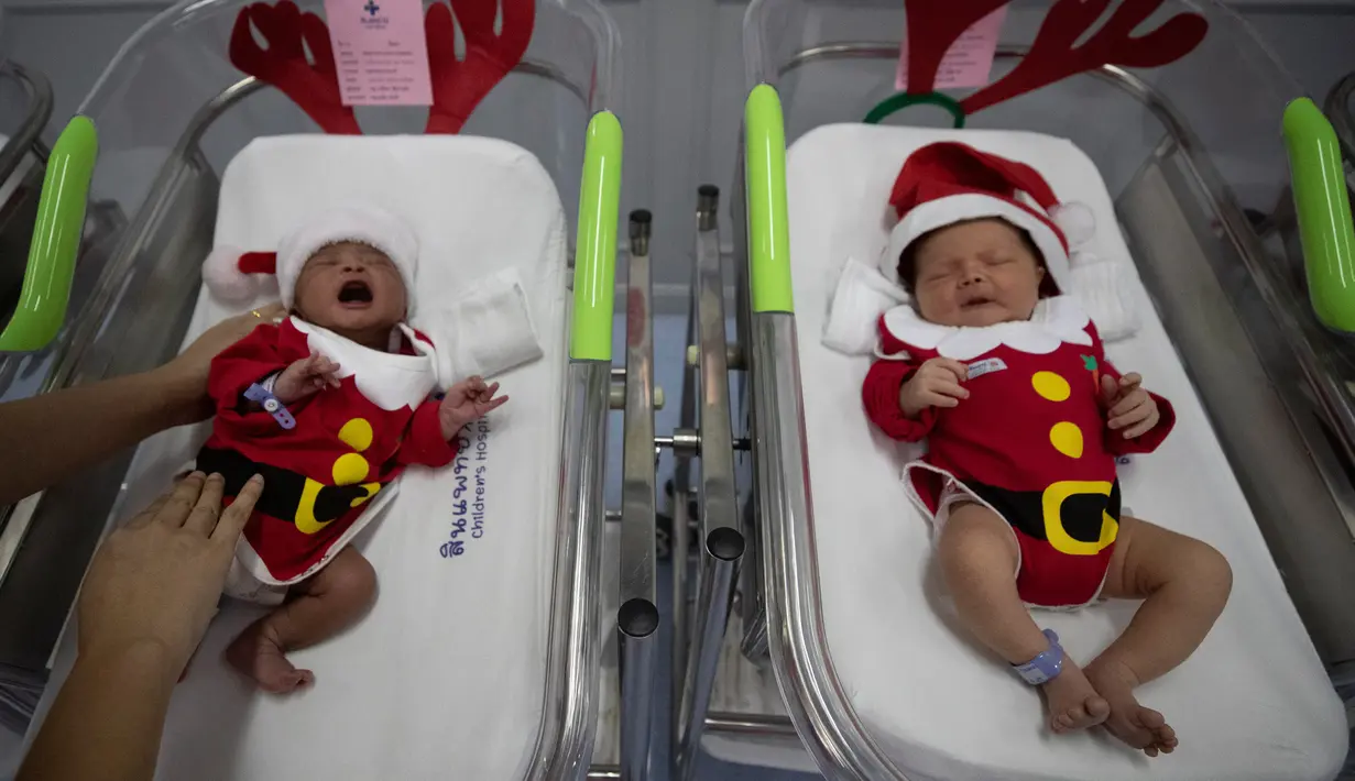 Perawat merawat bayi yang baru lahir di Rumah Sakit Synphaet, Bangkok, Thailand, Selasa (24/12/2019). Bayi-bayi tersebut dipakaikan kostum sinterklas untuk menyambut Hari Raya Natal. (AP Photo/Sakchai Lalit)