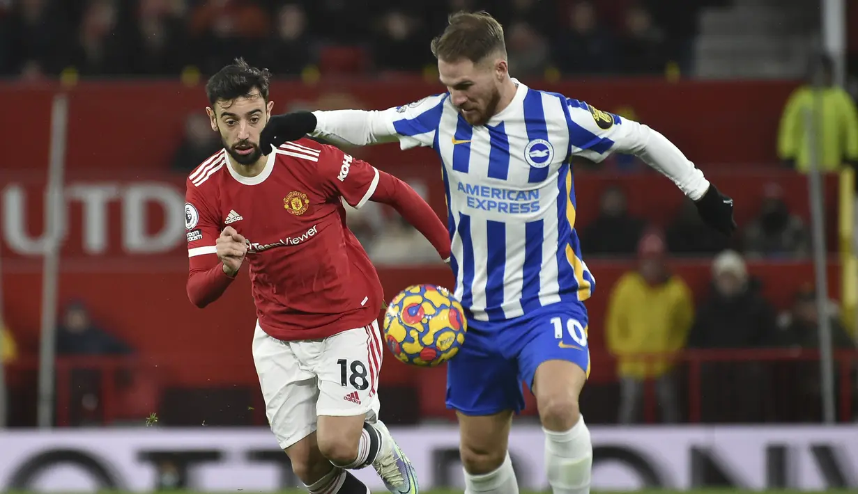 Gelandang Manchester United (MU) Bruno Fernandes berebut bola dengan gelandang Brighton & Hove Albion Alexis Mac Allister pada laga pekan ke-18 Liga Inggris di Old Trafford, Rabu dini hari WIB (16/2/2022). MU menang dengan skor meyakinkan 2-0. (AP Photo/Rui Vieira)