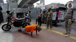 Petugas gabungan memberikan hukuman push up kepada warga yang tidak memakai masker saat razia Pembatasan Sosial Berskala Besar (PSBB) di Kawasan Jalan Fatmawati, Jakarta, Selasa (28/4/2020). Penertiban terkait pelaksanaan PSBB Jakarta dan memutus rantai penyebaran COVID 19. (merdeka.com/Imam Buhori)