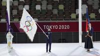 Presiden Komite Olimpiade Internasional Thomas Bach mengibarkan bendera Olimpiade saat Gubernur Tokyo Yuriko Koike (kiri) dan Wali Kota Paris Anne Hidalgo (kanan) menyaksikan upacara penutupan di Stadion Olimpiade pada Olimpiade Musim Panas 2020, Minggu 8 Agustus 2021, di Tokyo. (AP/Lee Jin-man)
