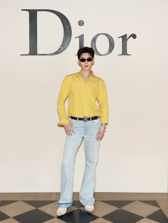 Deng Wei tampil vibrant dengan kemeja kuning berkerah dengan light jeans dan suede boots putih [Dior]