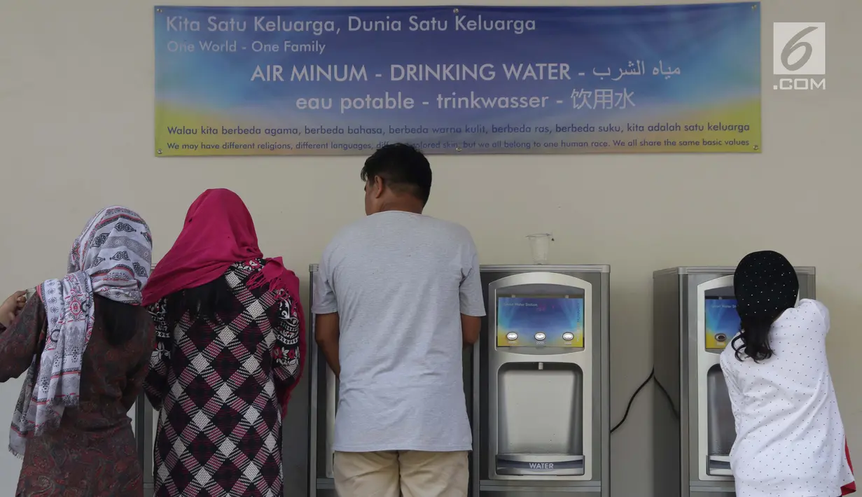Para pencari suaka mengambil air siap minum di halaman bekas Markas Kodim di kawasan Kalideres, Jakarta, Selasa (16/7/2019). Rata-rata para pencari suaka tersebut berasal dari Afghanistan, Pakistan, Somalia, Sudan, Iraq, dan Iran. (Liputan6.com/Helmi Fithriansyah)