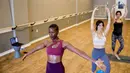 Lara Atella (tengah), Mariam Sufi (kanan), dan Lashone Wilson mengadakan kelas yoga online melalui webcam di Hot Yoga Capitol Hill, H Street, Washington, Amerika Serikat, Rabu (18/3/2020). Kelas yoga online ini digelar selama karantina virus corona COVID-19. (AP Photo/Andrew Harnik)
