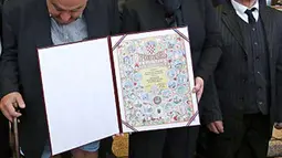 Kejadian memalukan saat celana panjang Kepala Komisi HAM Helsinki Kroasia, Ivan Zvonimir Cicak melorot hingga ke pergelangan kakinya tepat saat sesi foto dengan Presiden Kroasia Kolinda Grabar-Kitrarovic di Zagreb, Selasa (8/12). (dailymail.co.uk)