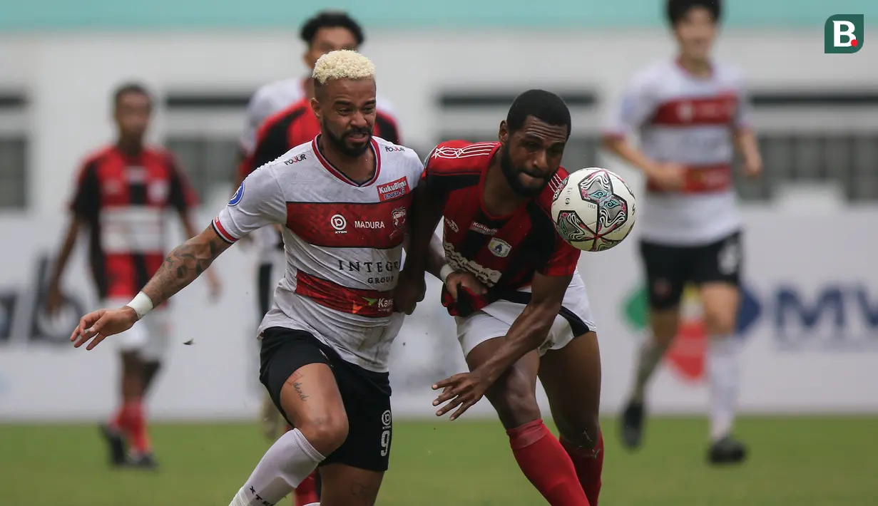 Pemain Madura United, Rafael Feital Da Silva (kiri) dan pemain Persipura Jayapura, Donni Monim berebut bola dalam laga pekan ke-6 BRI Liga 1 2021/2022 di Stadion Wibawa Mukti, Cikarang, Minggu (03/10/2021). (Bola.com/Bagaskara Lazuardi)