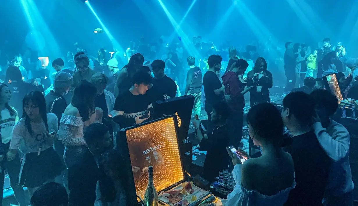 Suasana kelab malam di Wuhan yang dipadati pengunjung klub di Provinsi Hubei tengah, China (21/1/2021). Meski masih dalam suasana pandemi, tak sedikit pengunjung yang tak menggunakan masker. (AFP/Hector Retamal)